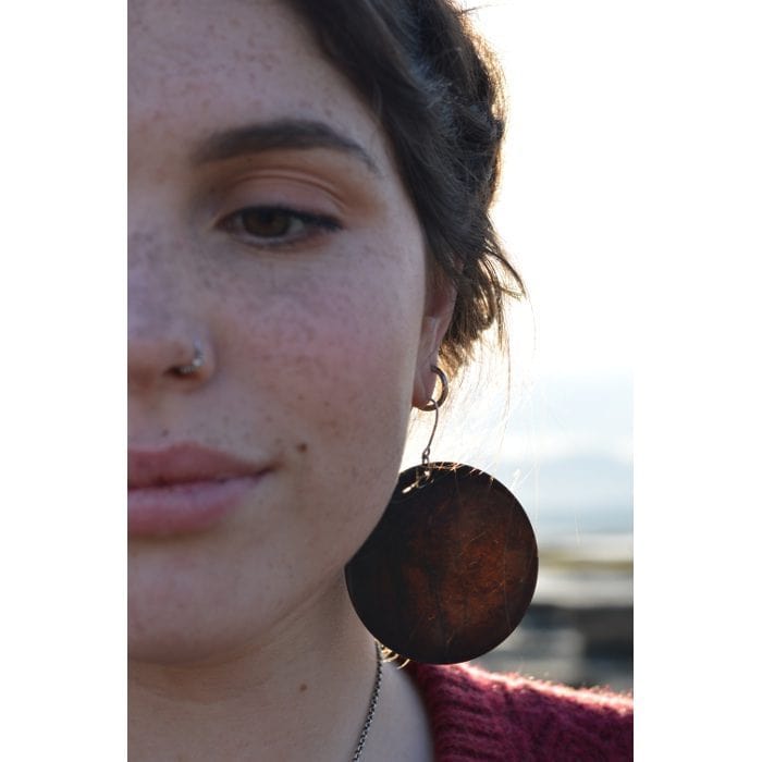 black pounamu earring with sunlight shining through