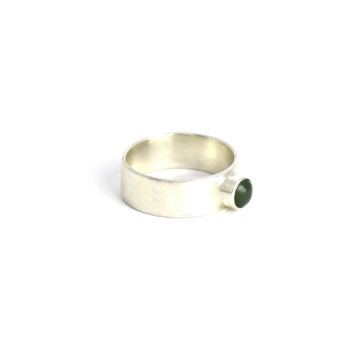 pounamu ring with wide band on hand